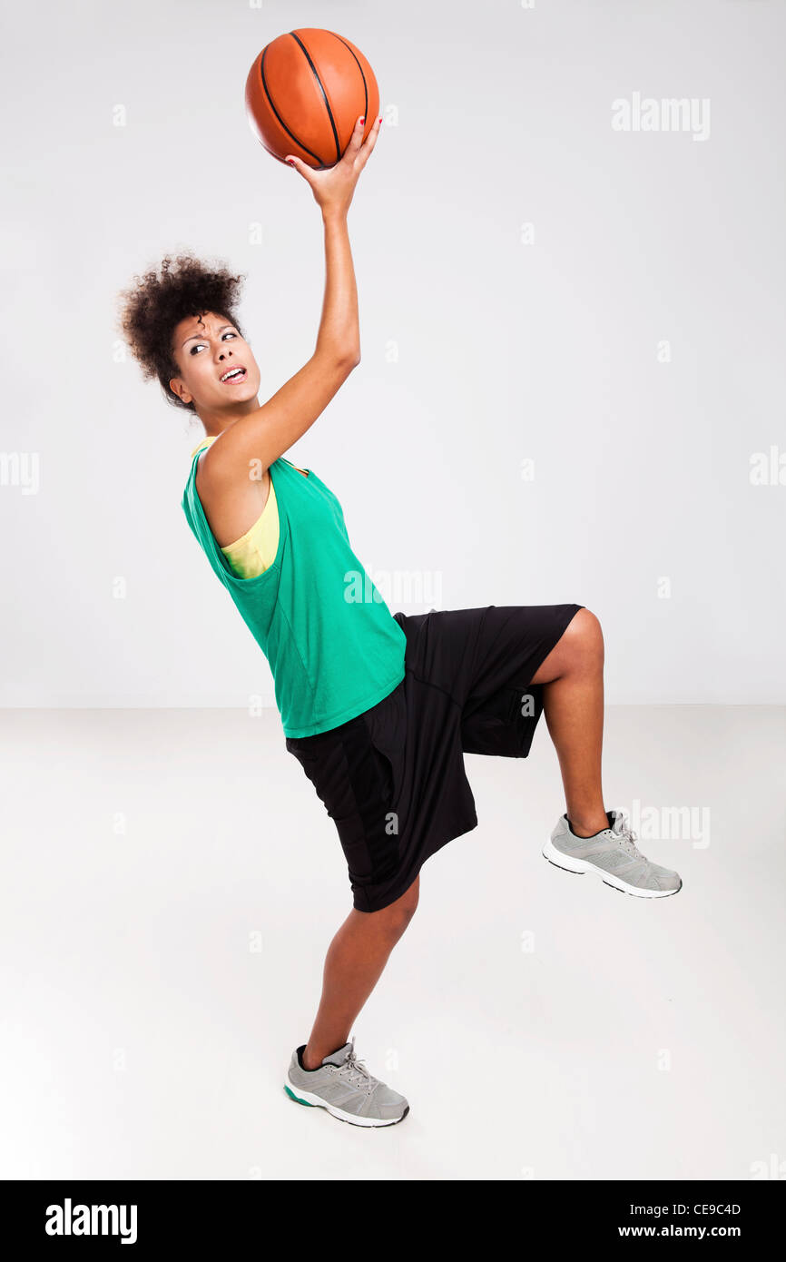 Athletic woman jumping with a basketball. Studio shot. Stock Photo