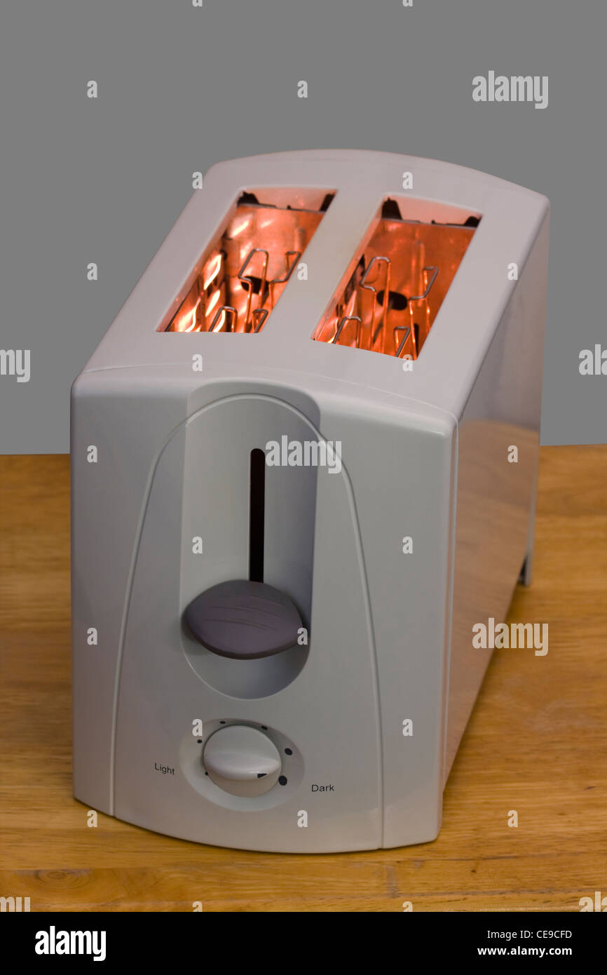White Toaster with glowing heating elements on a wooden countertop with