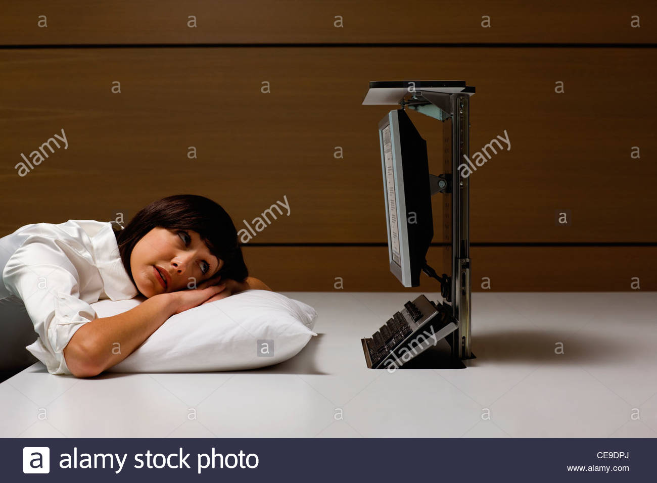 Businesswoman Laying On Pillow And Looking At Computer At Desk