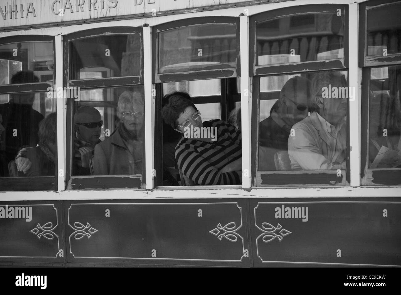 Tourists and locals take a ride in a Portuguese tram in Lisbon, Portugal. Stock Photo