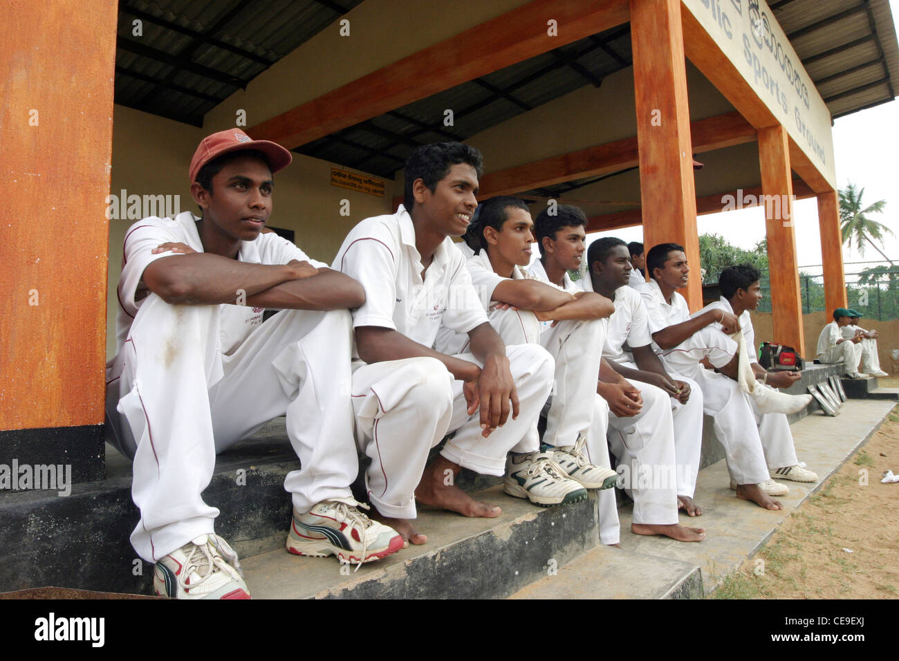 A young Sri Lankan Amateur Cricket Team watch a game from the stands, Galle, Sri Lanka Stock Photo