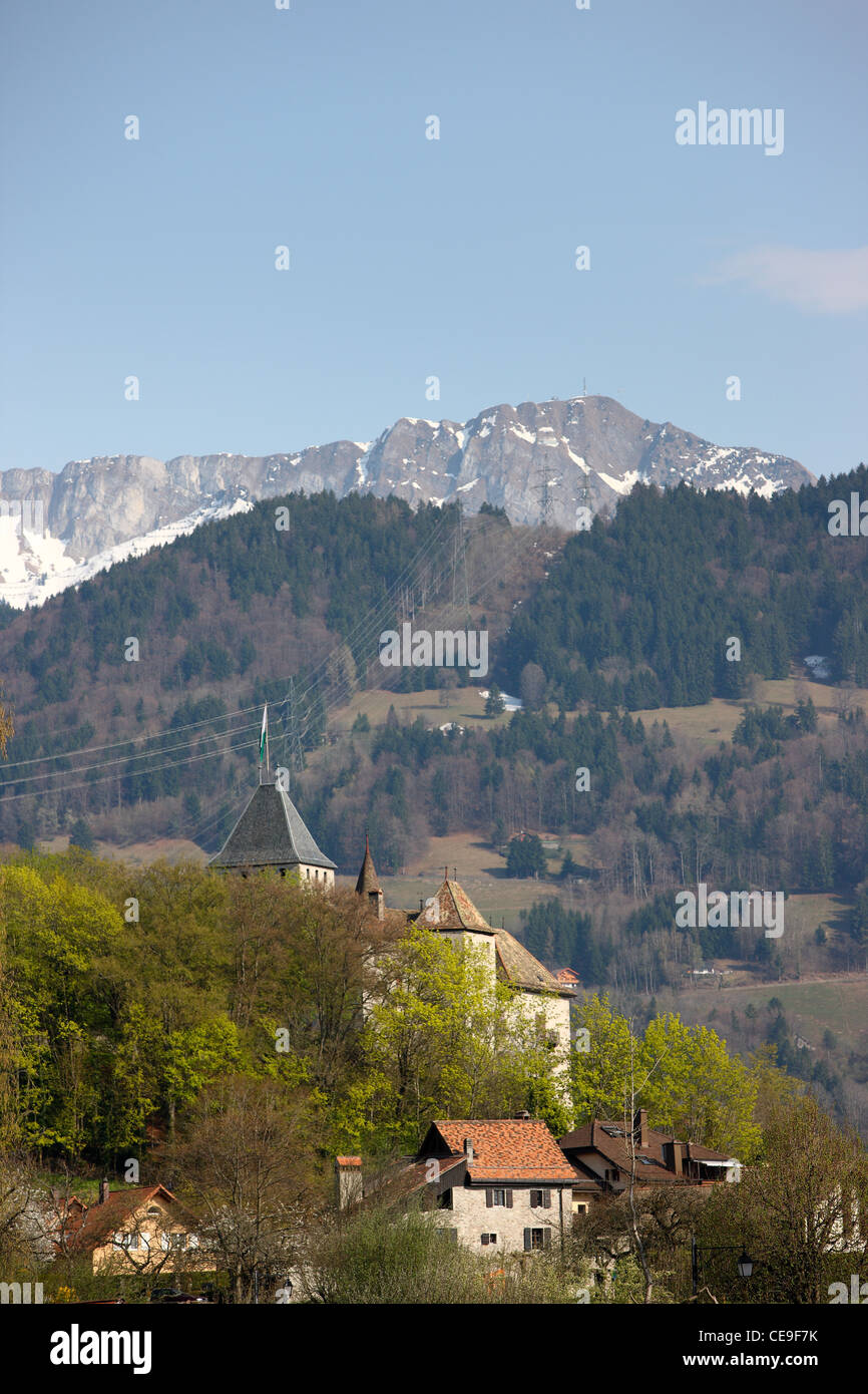 View of the church on the alpine hill. In the background are snowy peaks of the Alps. Spring in Switzerland. Stock Photo