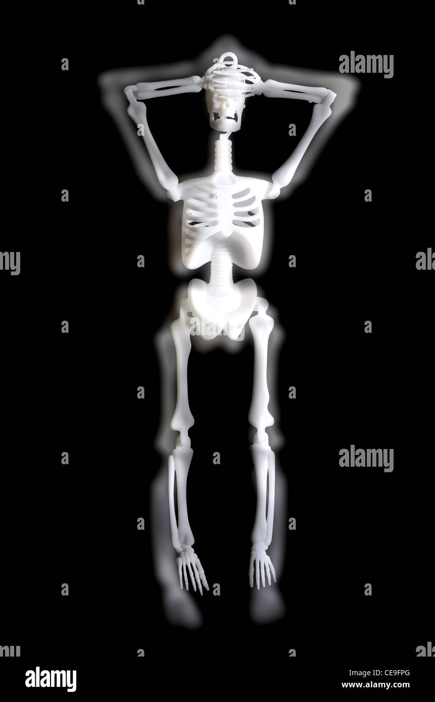 Plastic skeleton with hands over face with blurred effect Stock Photo