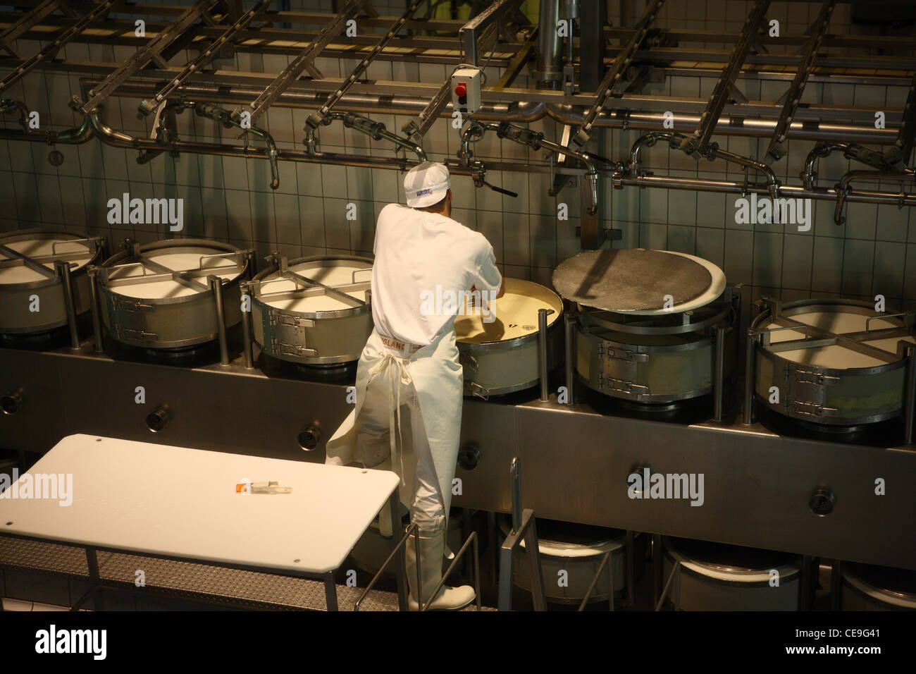 Cheese factory in Gruyères, Switzerland. Factory worker takes samples