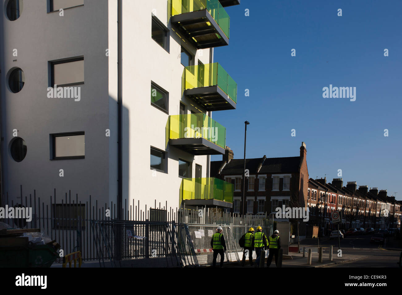 Workmen and new apartments in a block developed by Skanska in