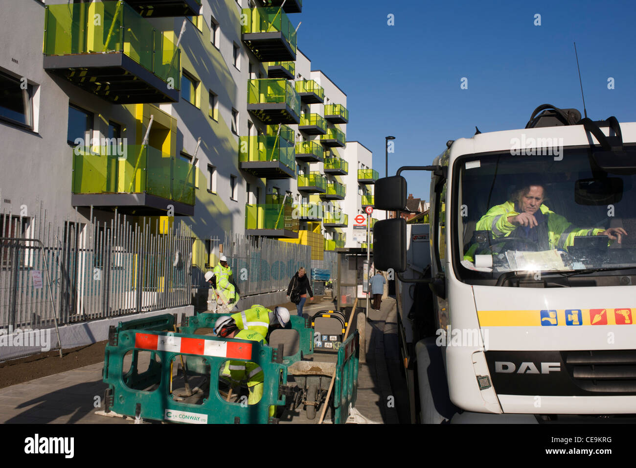 Workmen and new apartments in a block developed by Skanska in