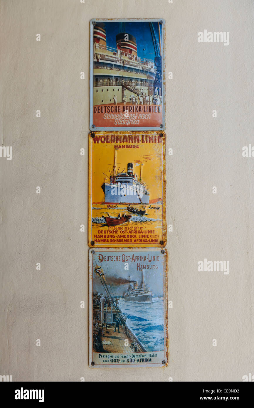 Old advertisement shields / plates on the wall of  'Woermann Haus'. Swakopmund, Namibia. Stock Photo