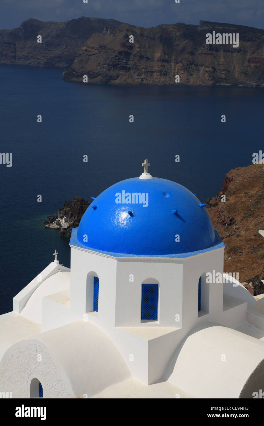 Blue Byzantine Greek Orthodox church dome with caldera in background, Oia, Santorini, Cyclades, Greece Stock Photo