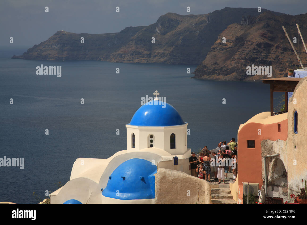 Blue Byzantine Greek Orthodox church dome with caldera in background, Oia, Santorini, Cyclades, Greece Stock Photo