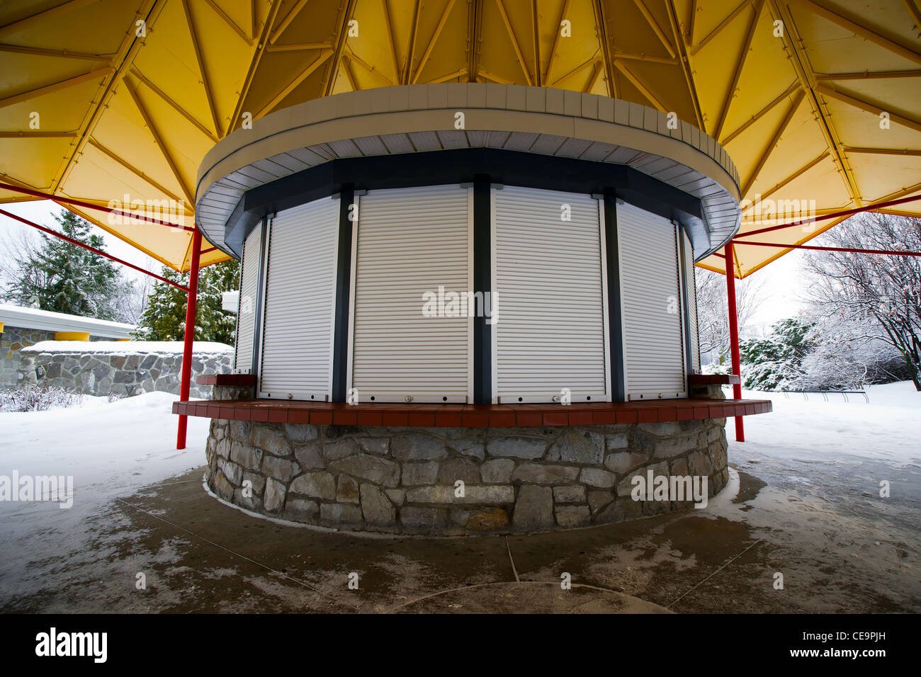 A small, closed and shuttered circular kiosk in a municipal park in winter. Stock Photo