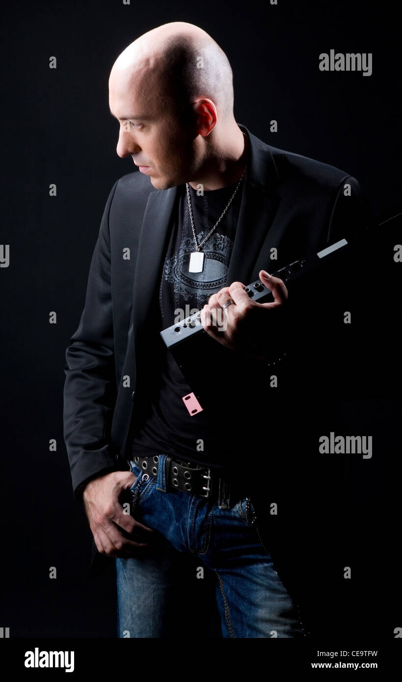 young man in a black suit on a black background Stock Photo - Alamy