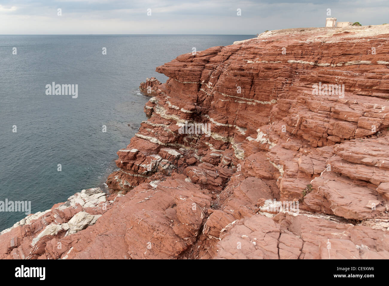 Red layered rocks on the sea Terrasini in Sicily Stock Photo