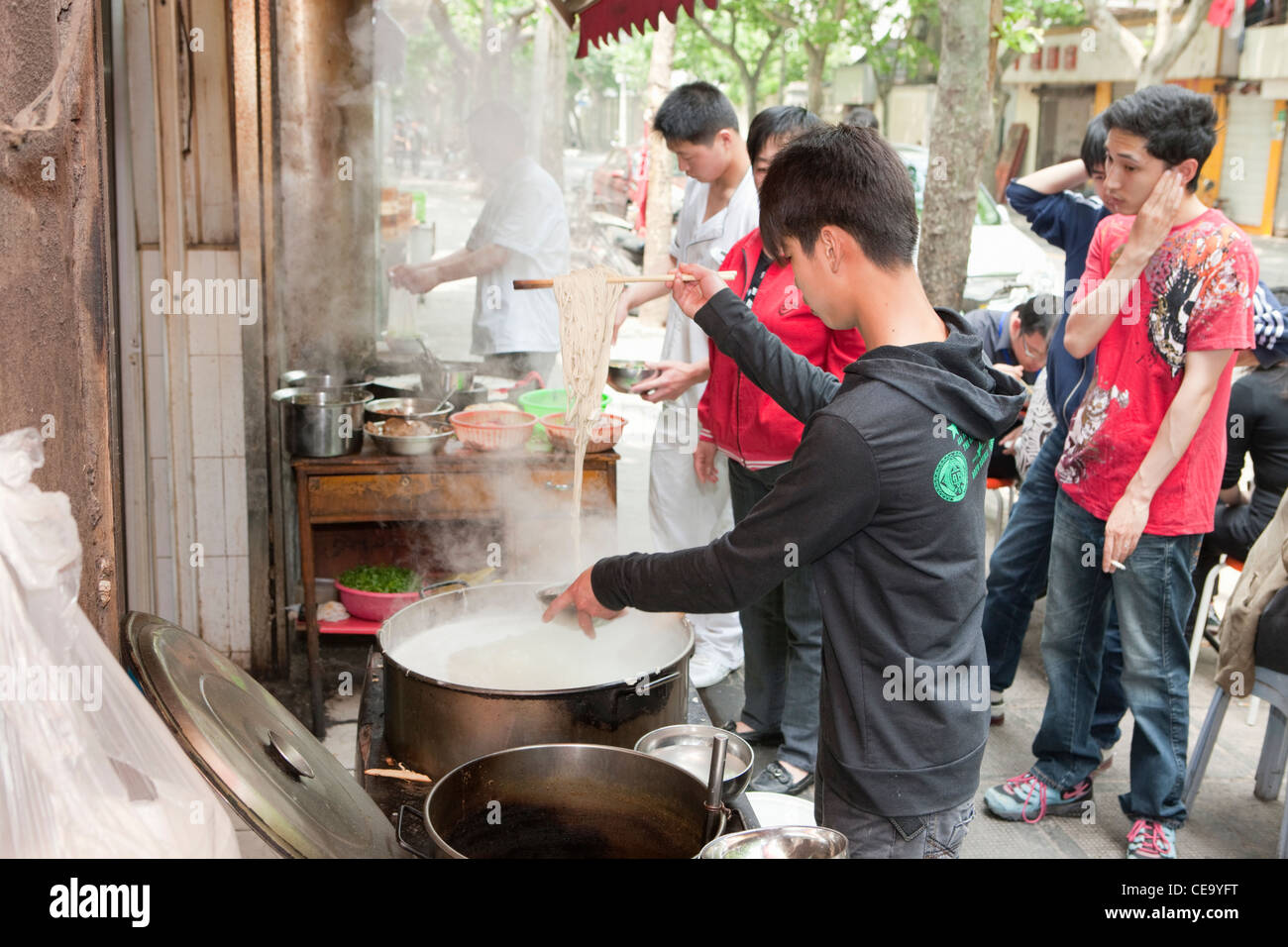Boy serving noodles; French Concession; Shanghai; China Stock Photo