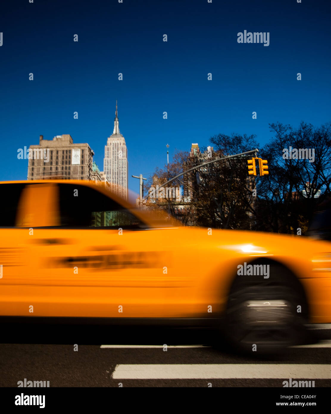 Traditional NYC Yellow taxi, Empire State building in the background, USA Stock Photo