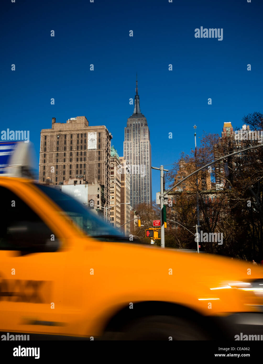 Traditional NYC Yellow taxi, Empire State building in the background, USA Stock Photo