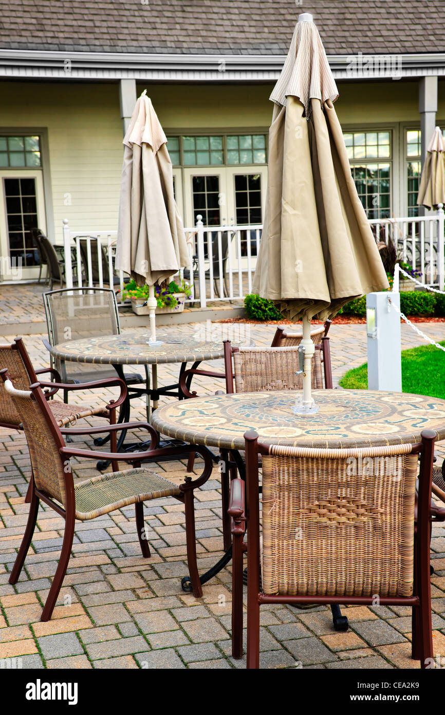 Patio furniture with tables chairs and umbrellas Stock Photo