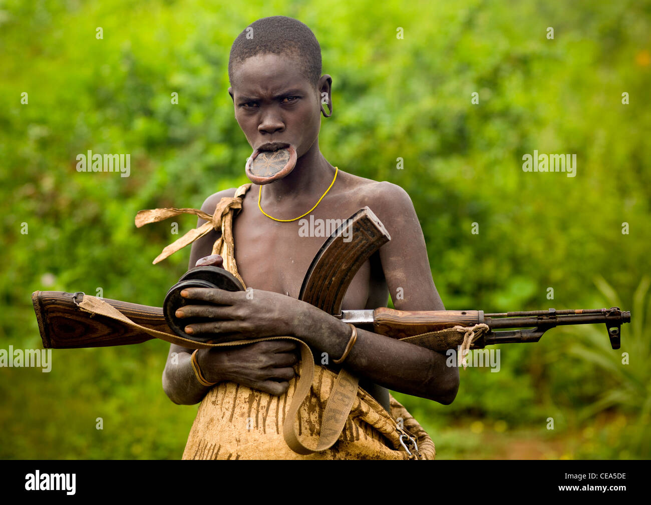 Lip Plate Woman With Kalashnikov Rifle And Two Clay Plates In Her Hands Ethiopia Stock Photo