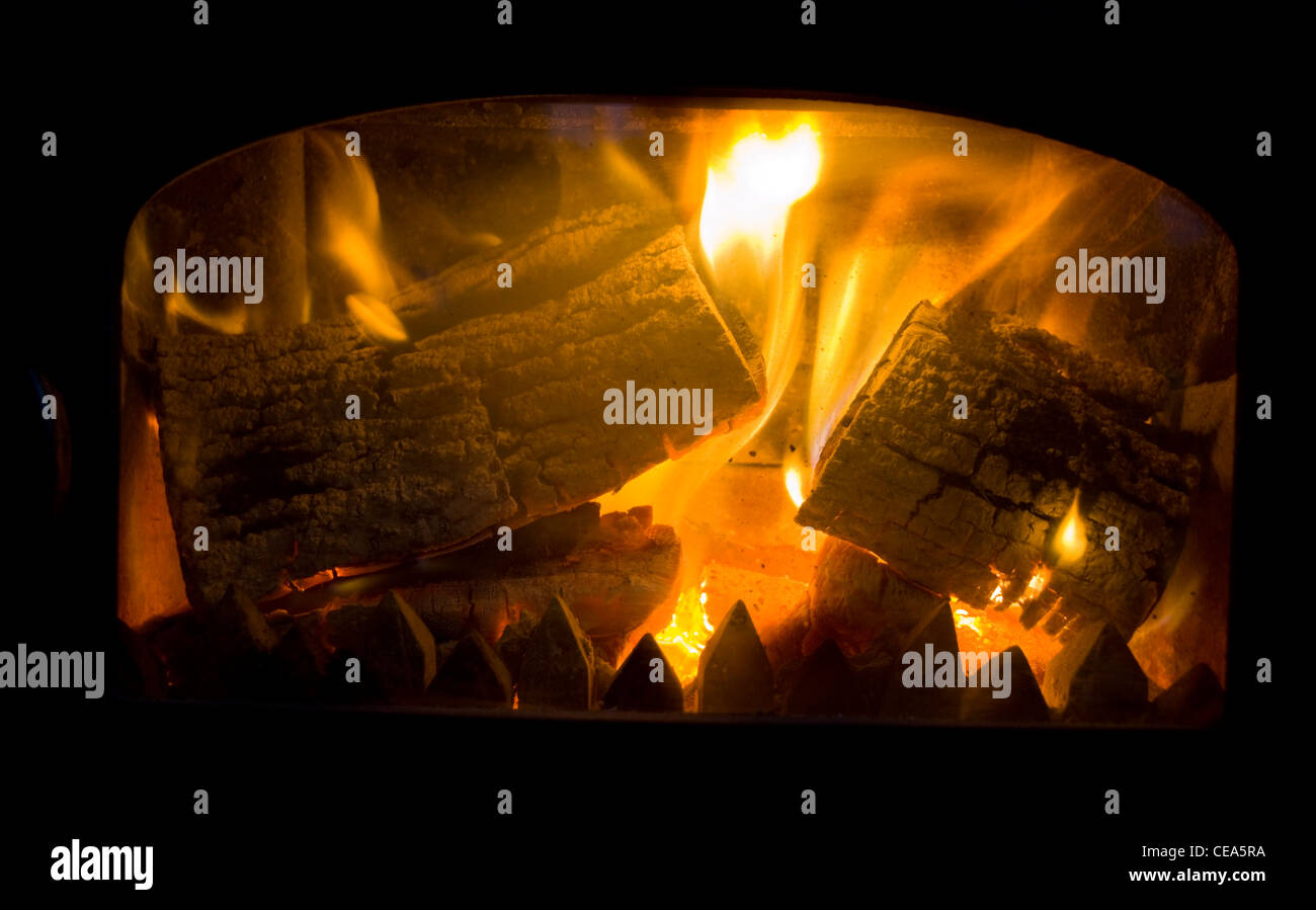 Logs burning in a wood burning stove Stock Photo Alamy