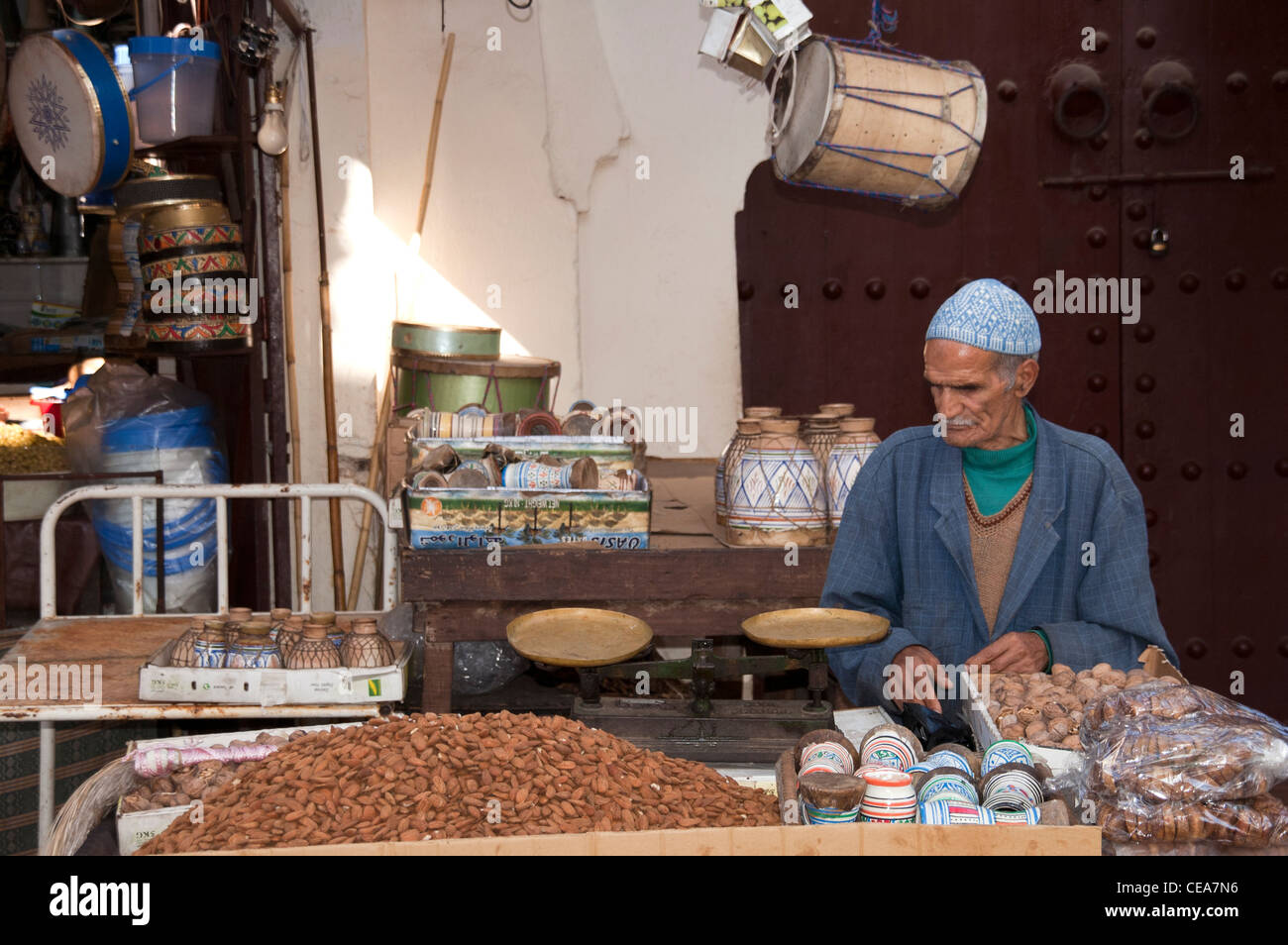 Man Selling nuts and pottery on a small stall in The Medina of Fez, Morocco Stock Photo