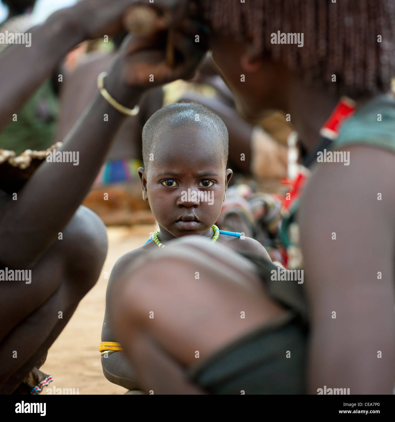 Baby Watching Ochred Braids Haircut Of Banna Woman Ethiopia Stock Photo