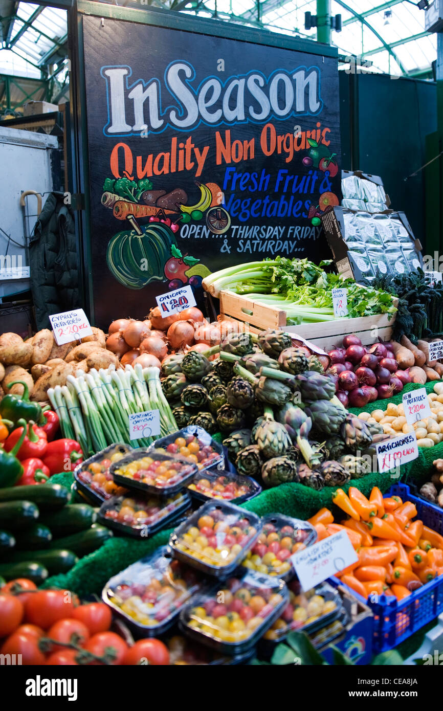 Borough Market London greengrocer stall advertising in season NON organic fresh fruit & vegetables onions artichokes etc Stock Photo