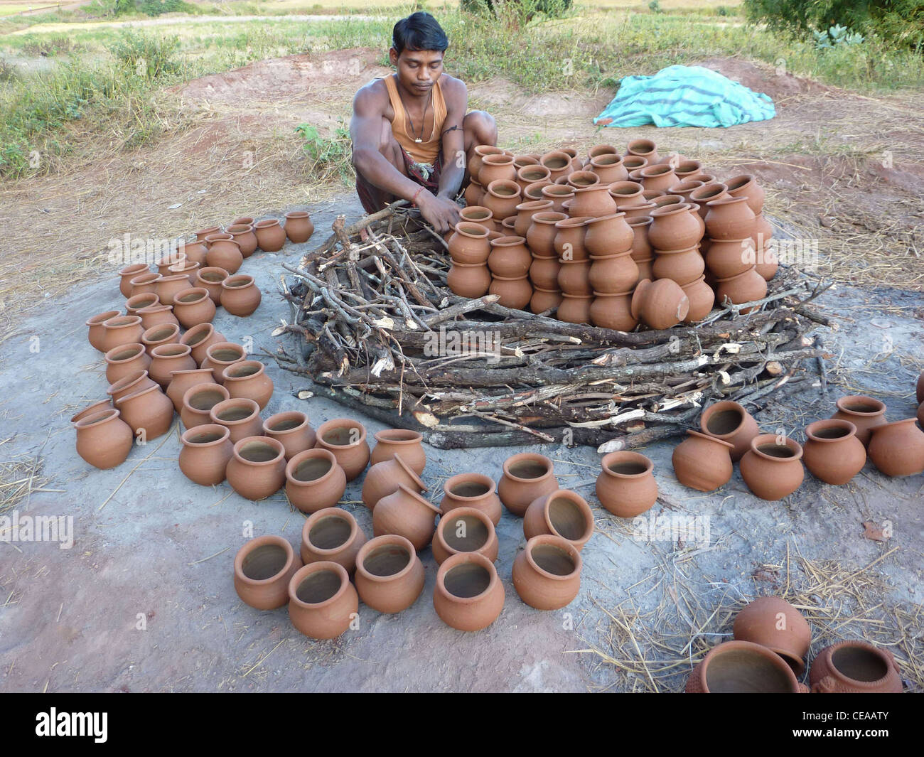 ORISSA, INDIA - Nov 13 -Potter builds an outdoor kiln for clay pots on Nov 13, 2009, in Orissa, India Stock Photo