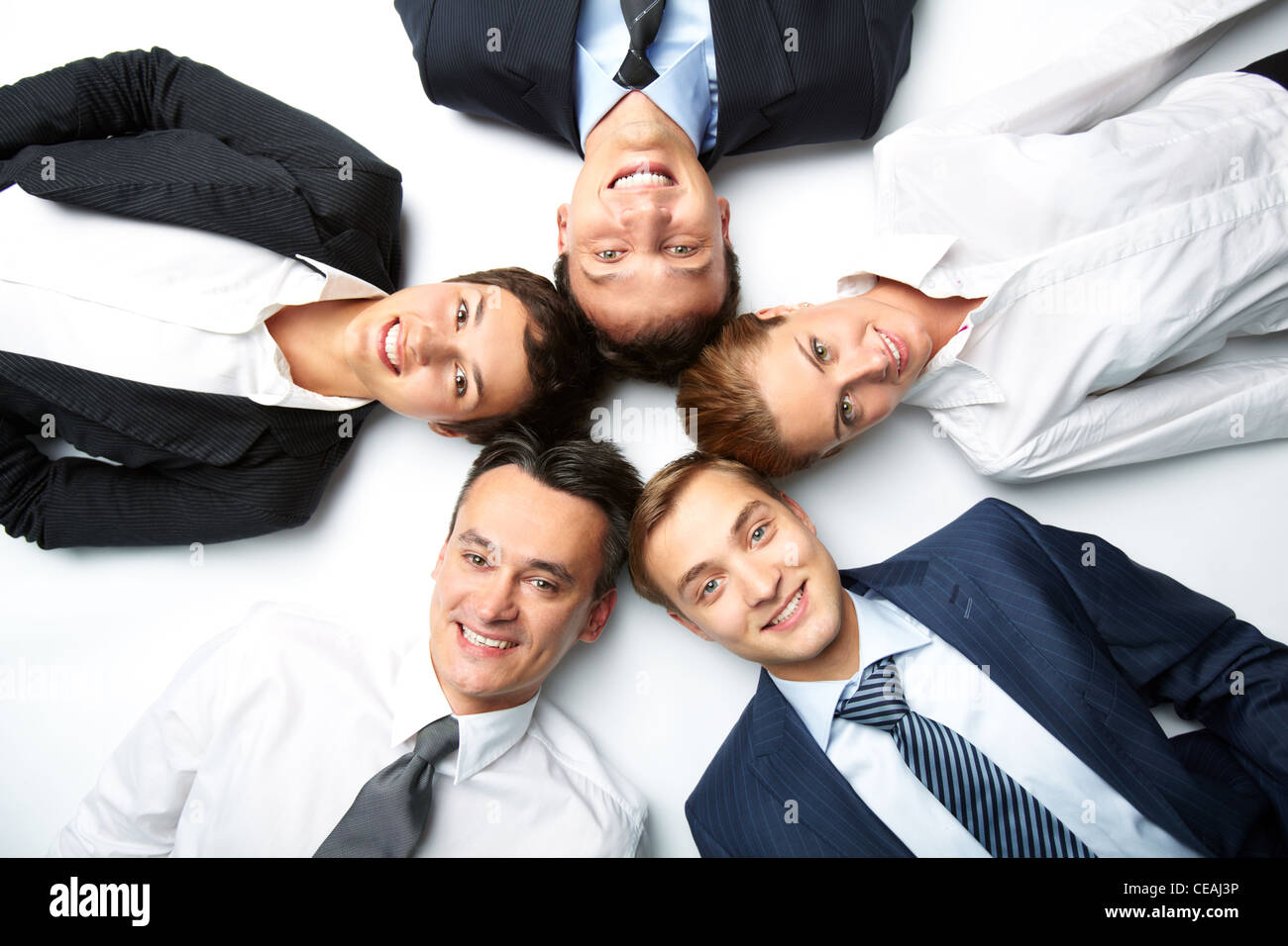 Five Business People Lying On The Floor Looking At Camera And