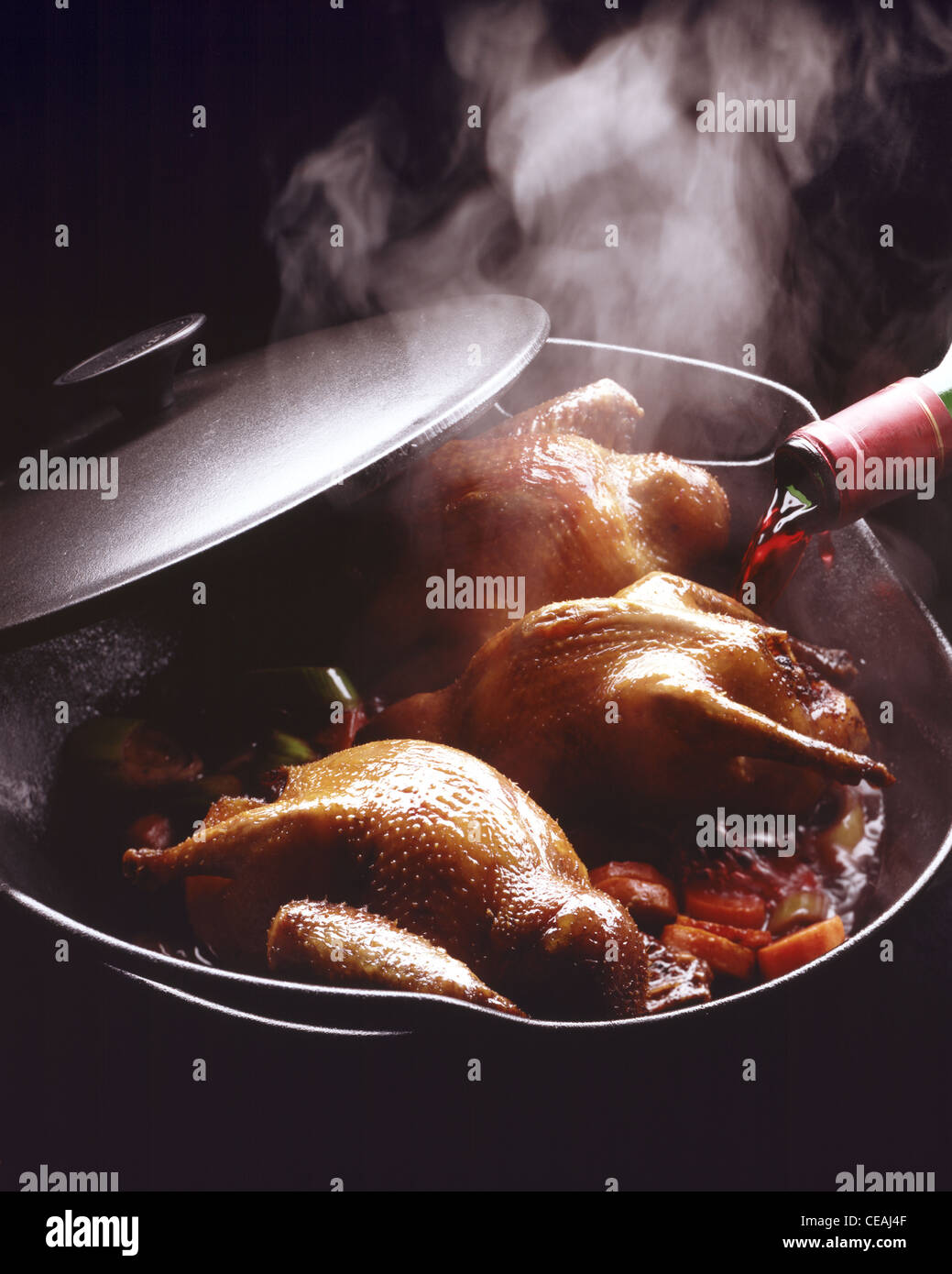 Step: Pour redwine on pigeons in roasting tin Stock Photo
