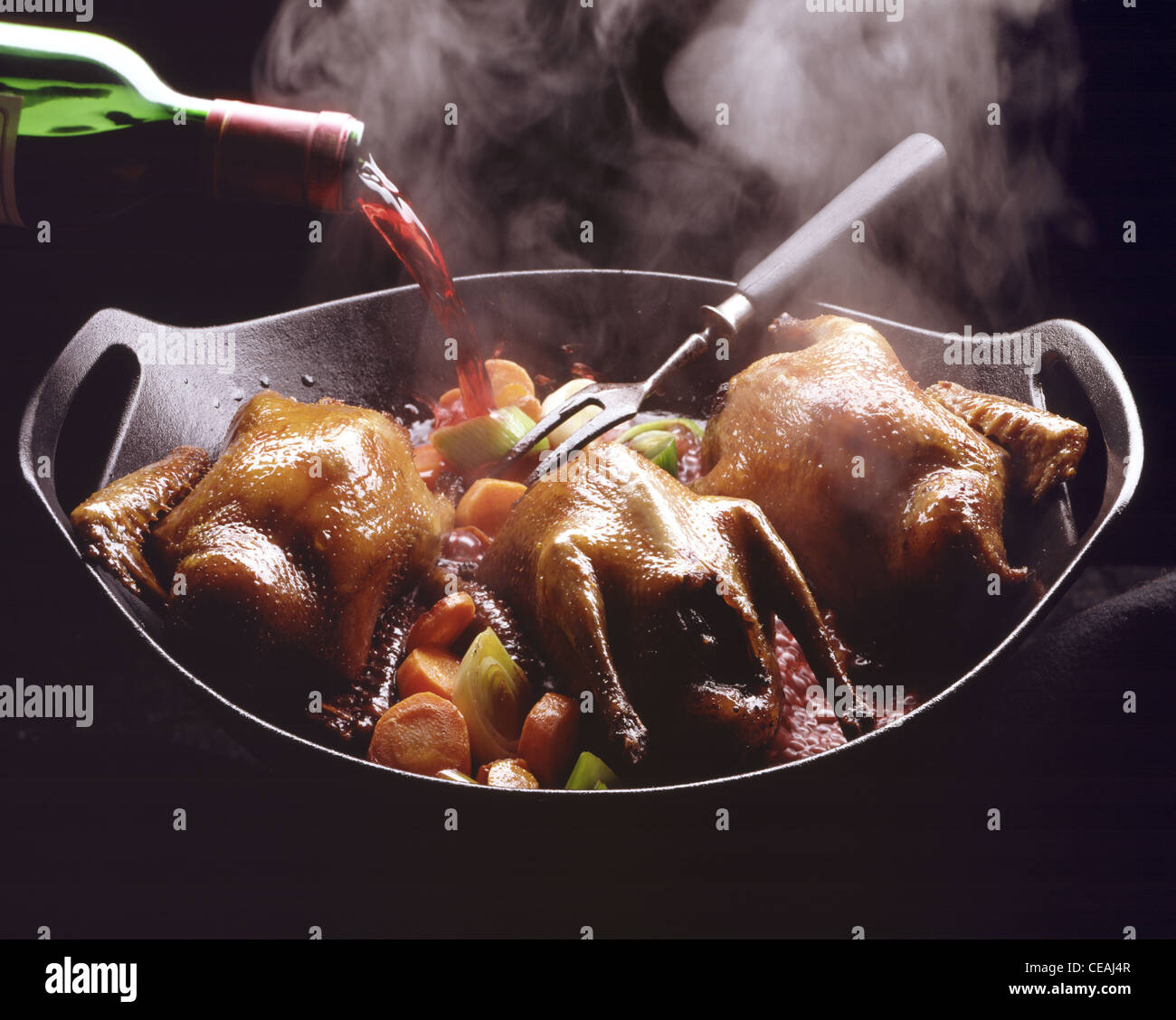 Step: Pour redwine on pigeons in roasting tin Stock Photo