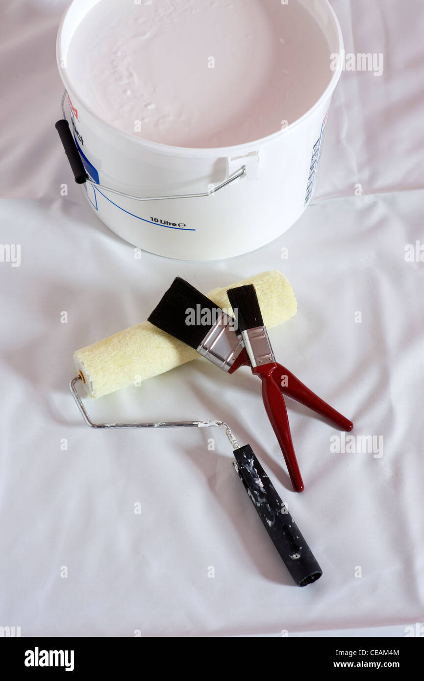 paint brushes roller and tub of white paint Stock Photo Alamy