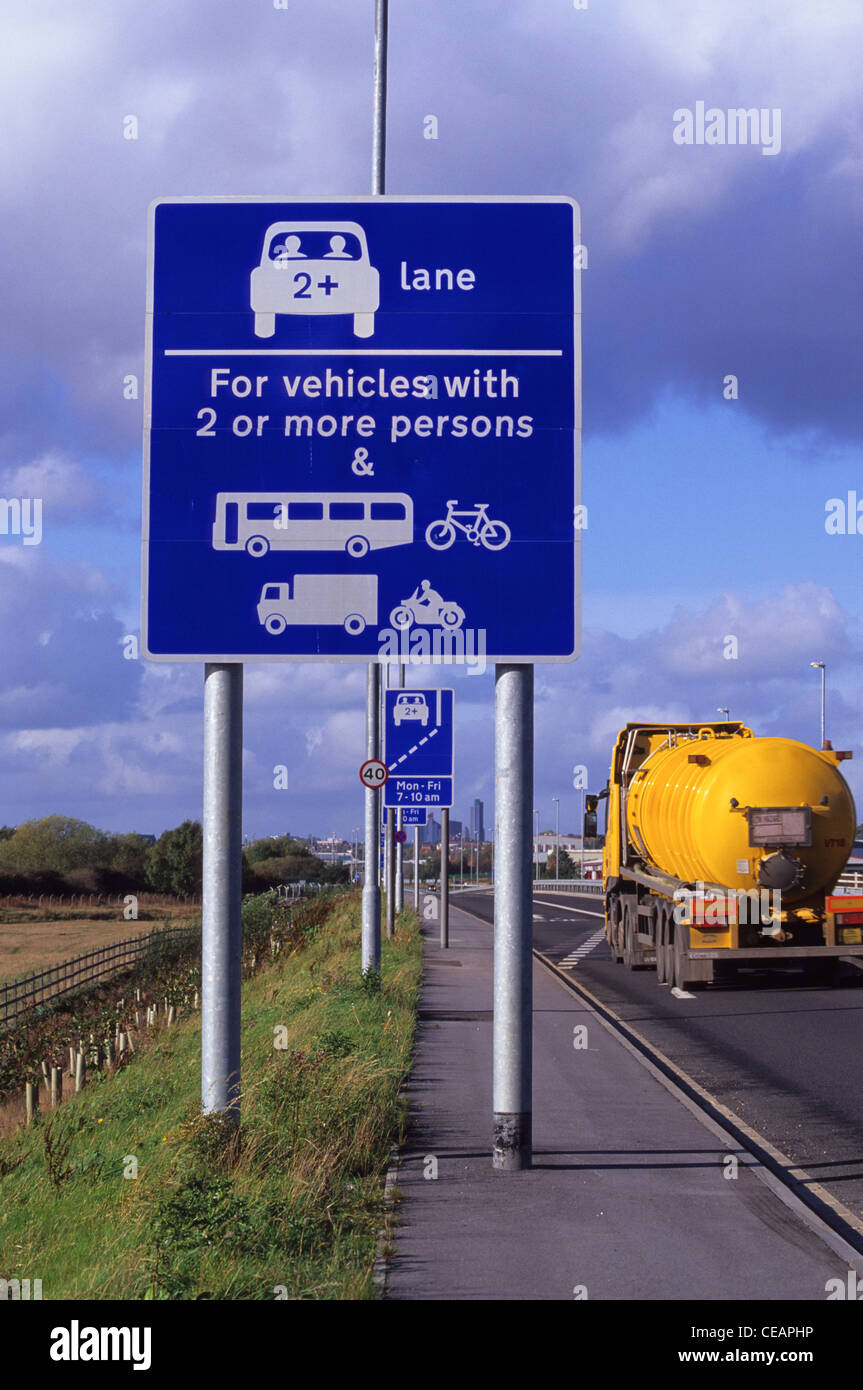 lorry passing warning roadsign of high occupancy lane ahead for vehicles carrying two or more people to ease congestion Leeds UK Stock Photo