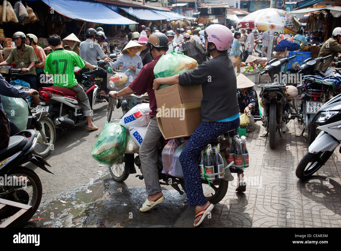 Motor bike delivery driver loaded with goods at Binh Tay Market Chinatown Cholon Ho Chi Minh City Stock Photo