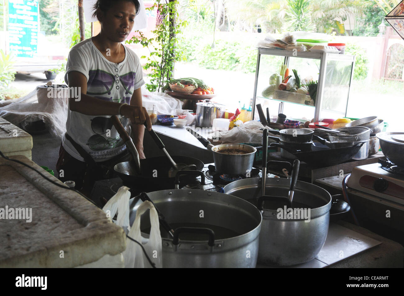 Thai girl cooking in roadside restaurant, Kanchanaburi, Thailand Stock
