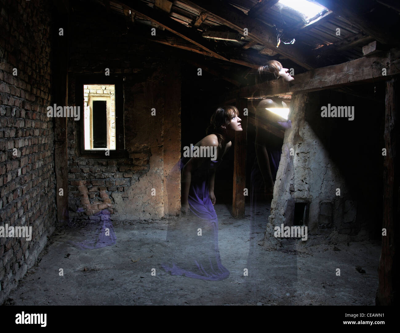 Multiple exposure of a young woman standing in attic looking at light beam coming through window Stock Photo