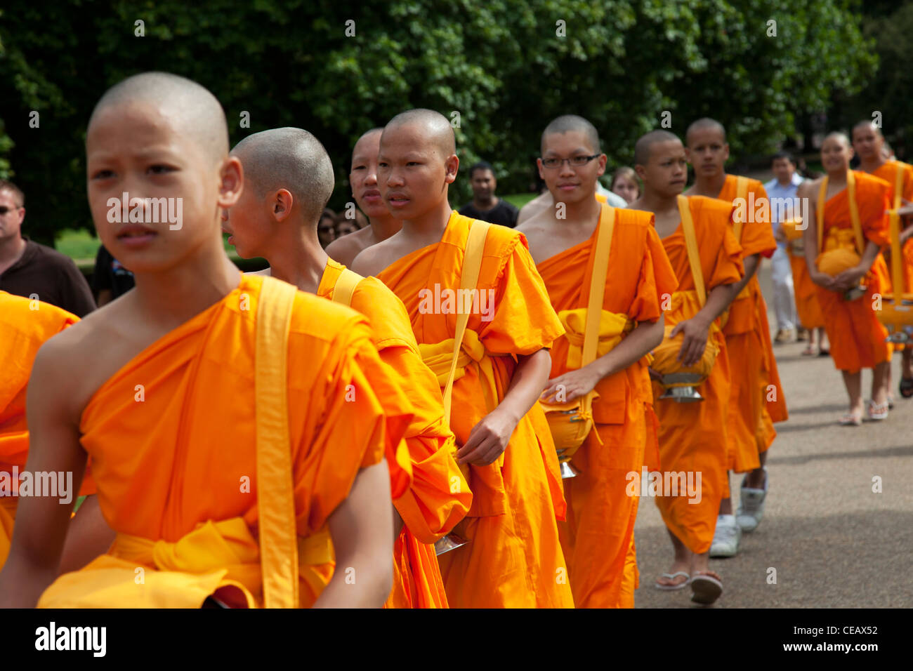 Young Tibetan Buddhist monks wearing orange robes walk through Green Park,  London, UK Stock Photo - Alamy