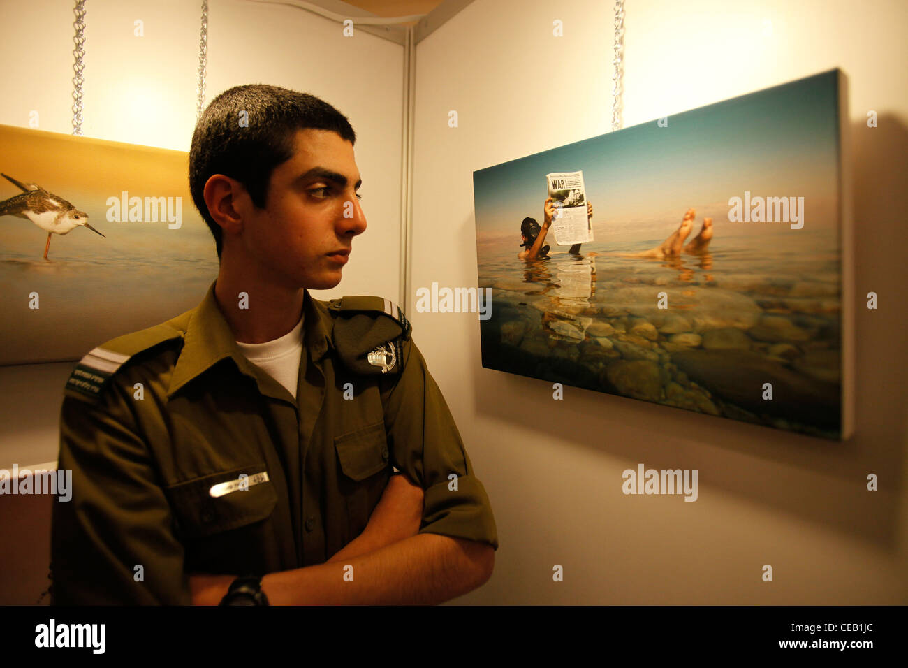 Israeli soldier attends the opening of a unique exhibition of visual arts by Israel’s soldiers in Tel Aviv Israel Stock Photo