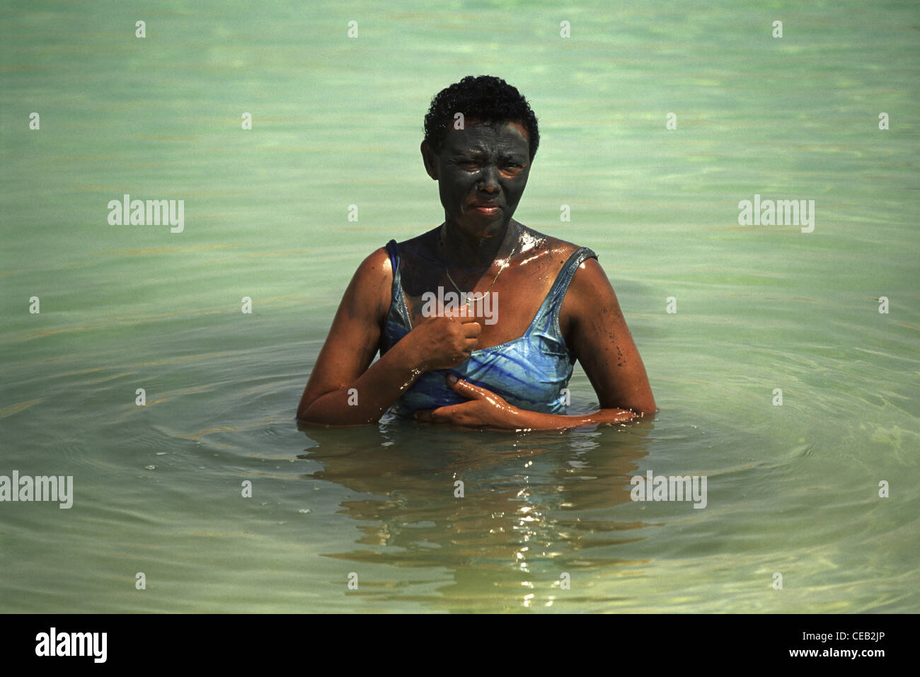 A tourist from Africa smeared with natural black mud from the Dead Sea