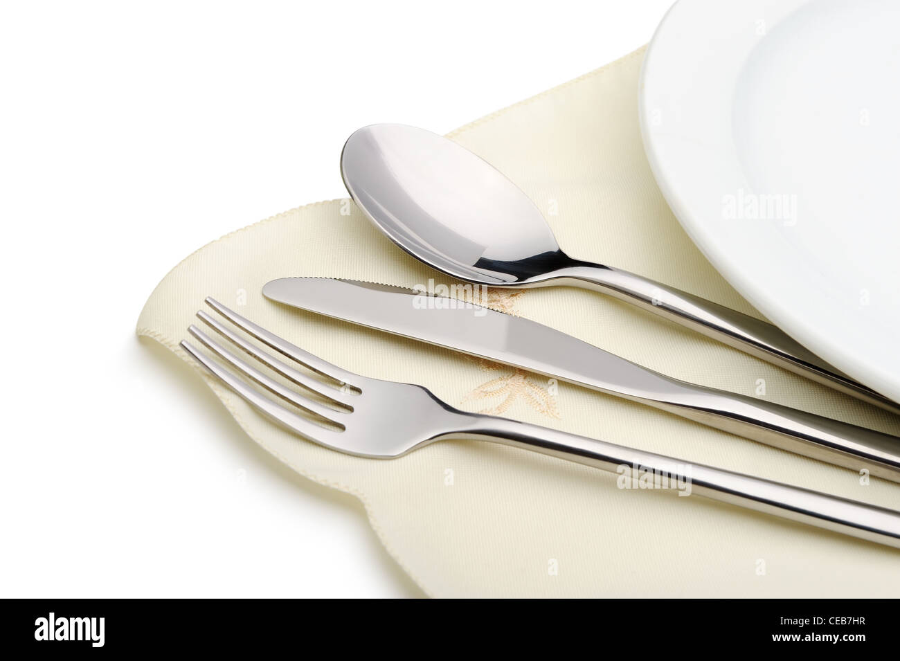 Spoon, fork and a knife lie on serviette. It is isolated on a white background Stock Photo