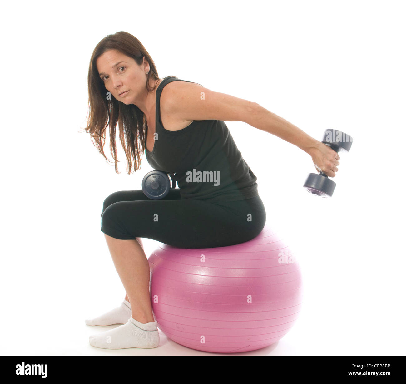 middle age woman fitness exercising strength training with dumbbell weights core training ball Stock Photo
