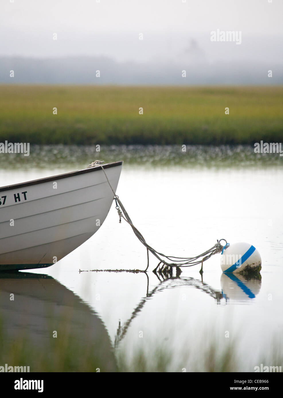 bow of small boat tied to mooring on misty day Stock Photo