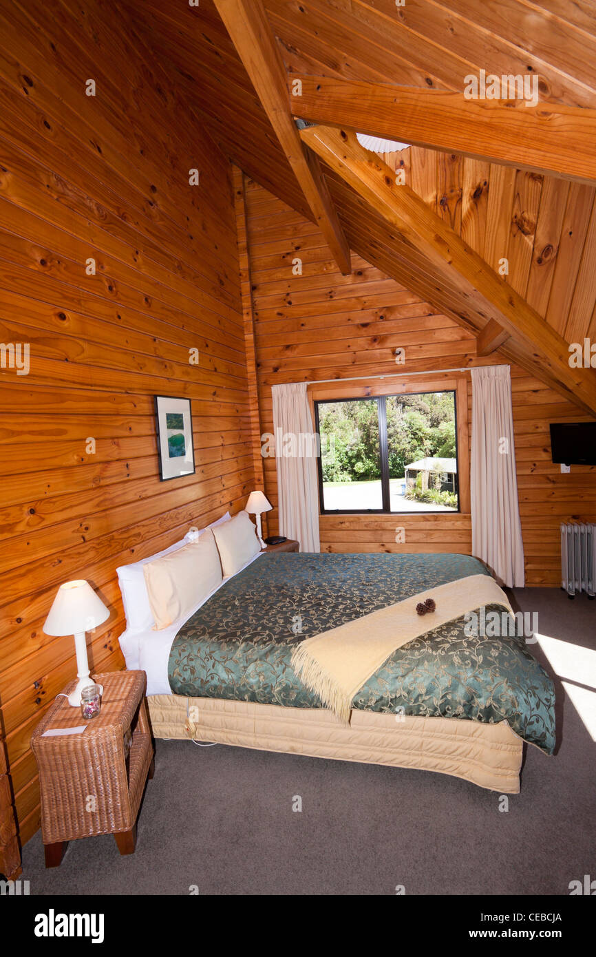 Interior of mountain wooden lodge double bedroom. Fox Glacier Lodge
