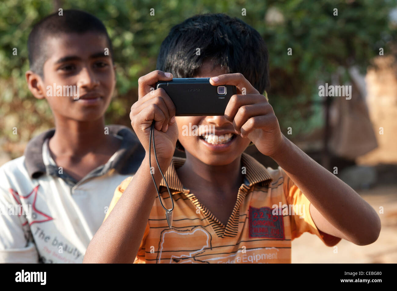 Indian boy taking a photo with a mobile phone in a rural indian village. Andhra Pradesh , India Stock Photo