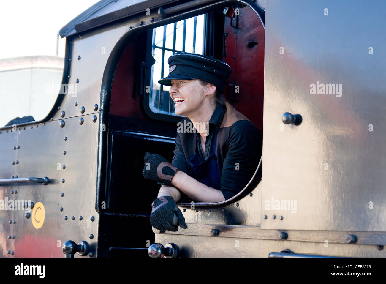 Steam locomotive pulling a train on the Llangollen Railway with the female engine driver laughing Stock Photo