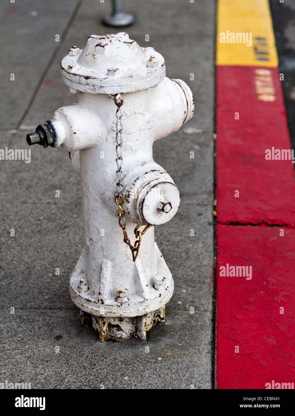 A San Francisco fire hydrant standing by a yellow and red painted kerb Stock Photo