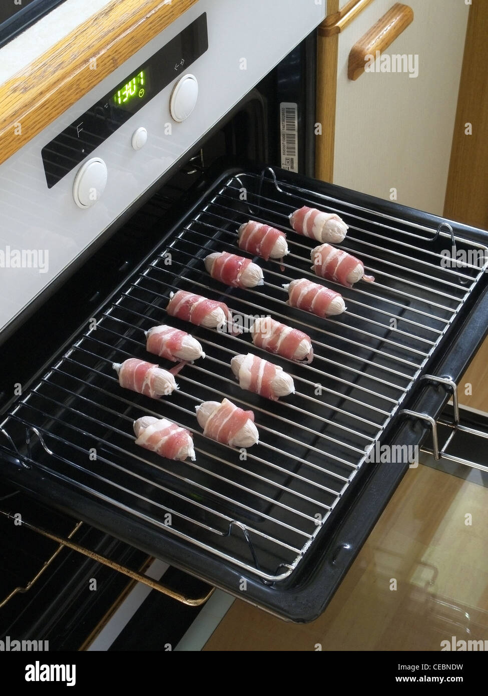 Uncooked Pigs In Blankets (sausages wrapped in bacon) on a Grill Pan