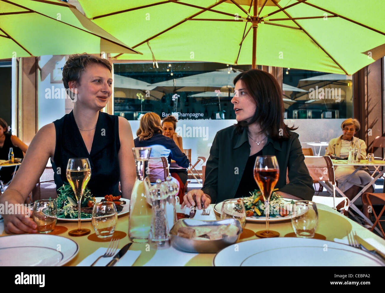 PARIS, France - Women Chatting, Sharing Lunch ion Terrace of Contemporary French Trendy Restaurant  (Now Closed) Conversation, Dining, Authentic French lifestyle Stock Photo