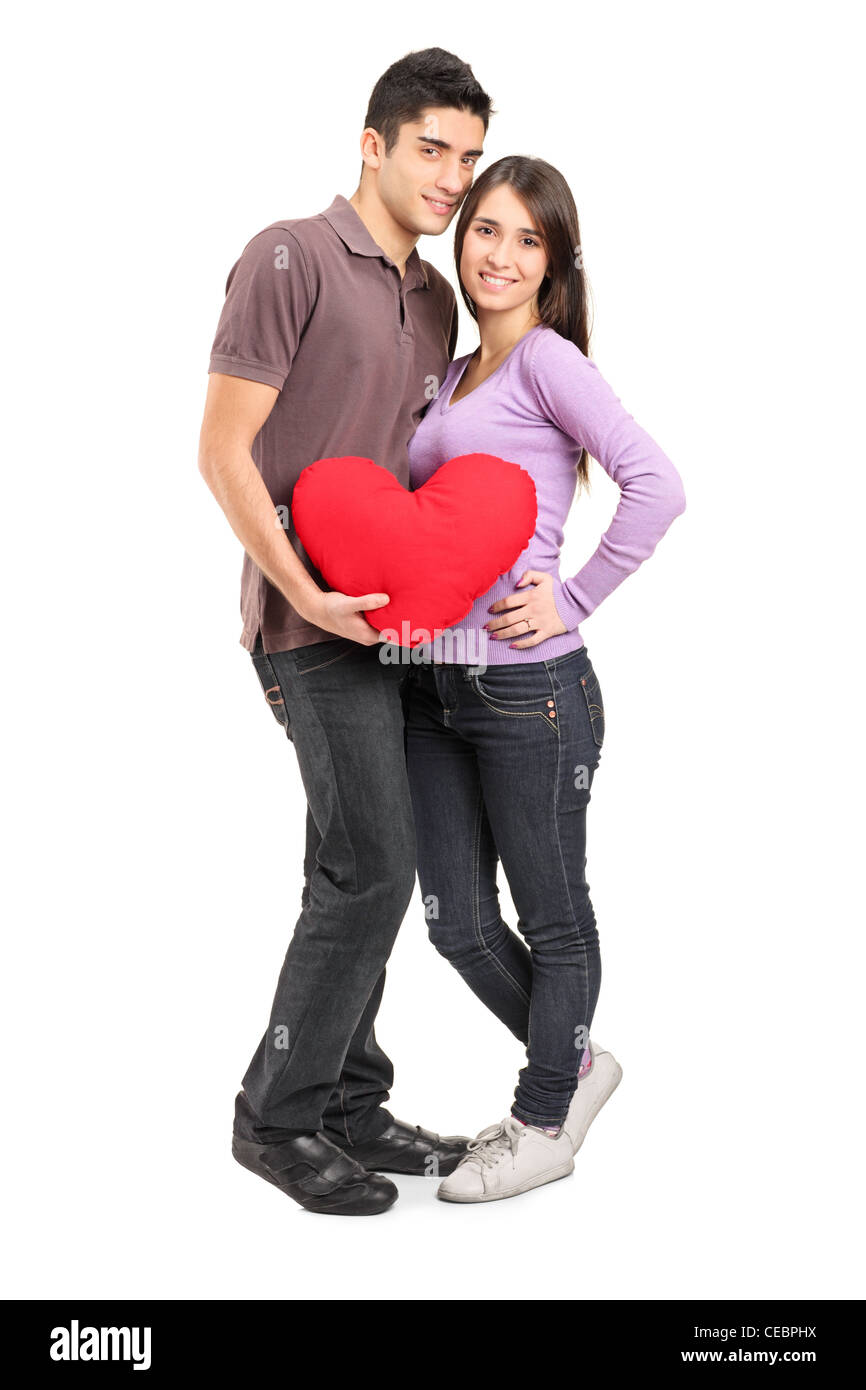 Full length portrait of a young loving couple holding a red heart ...