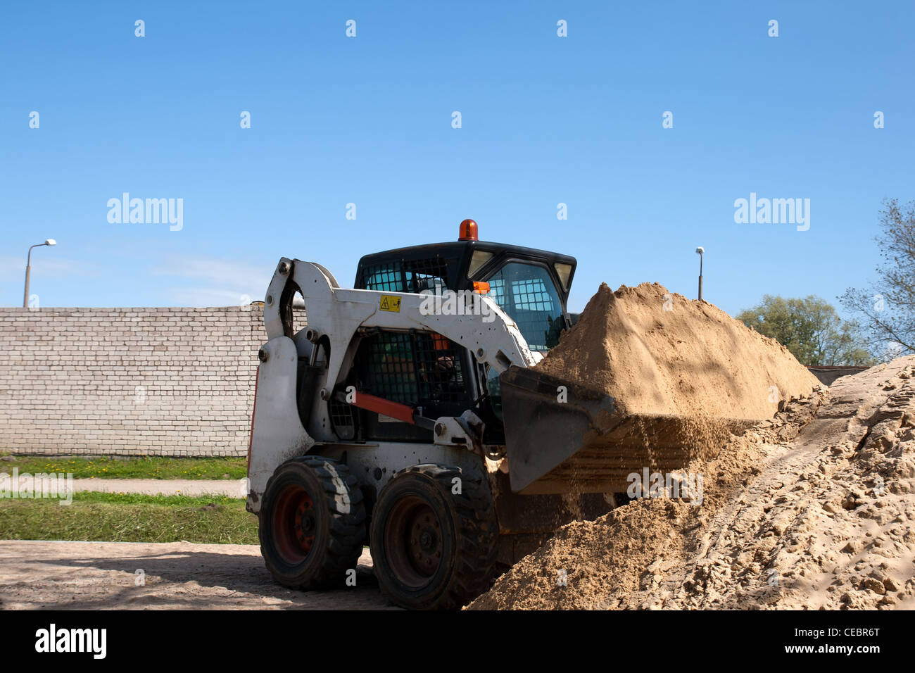 A bobcat doing some construction work with sand Stock Photo