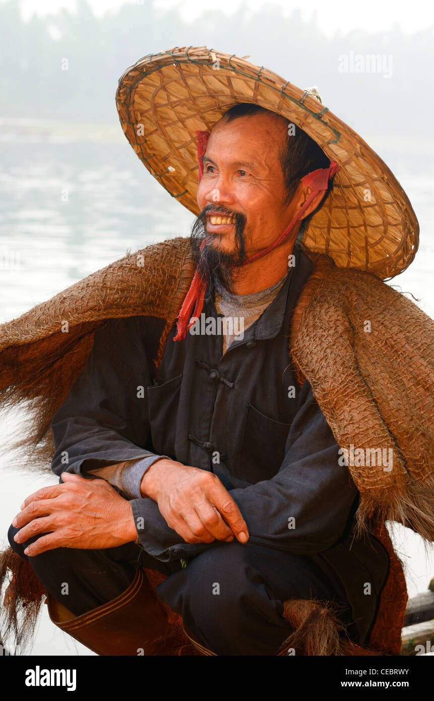 Close up of a smiling cormorant fisherman on the Li river at dawn Xingpingzhen Yangshuo, Guilin, Guangxi China Stock Photo