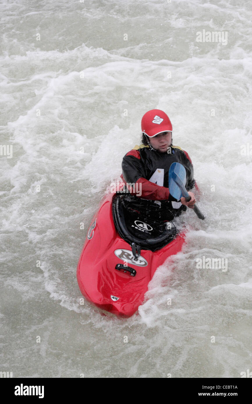 male man canoeist taking part in inter university competition on River Exe Exeter 4/2/12 shooting over a weir Stock Photo